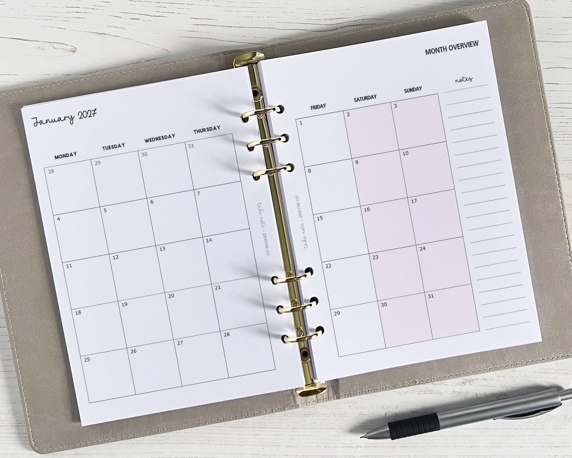 A5 monthly planner inserts with a classic design, displayed in an open planner, with a pen to the side.