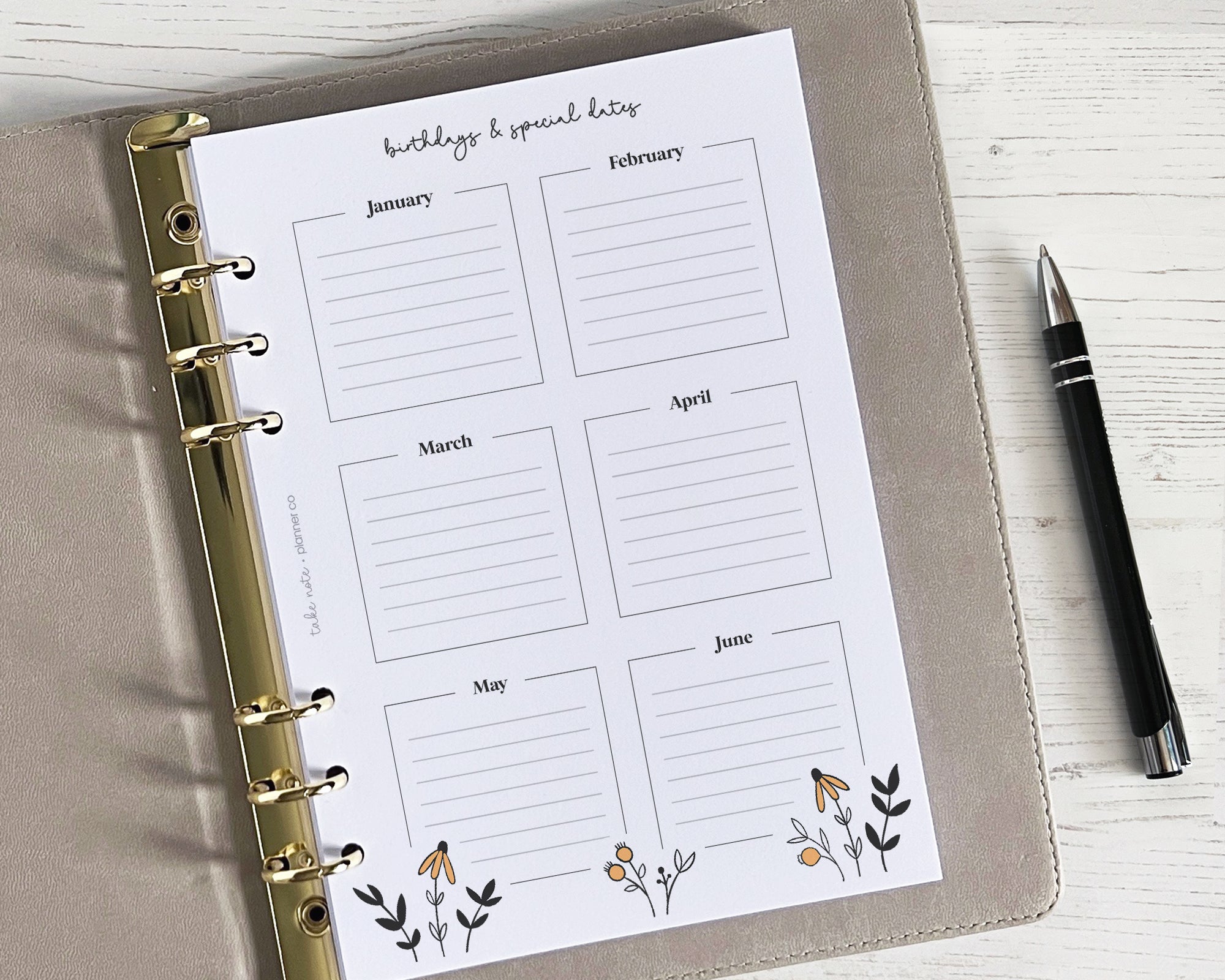 An undated yearly overview insert with months and spaces for birthdays, featuring a floral design and a gold spiral binding.
