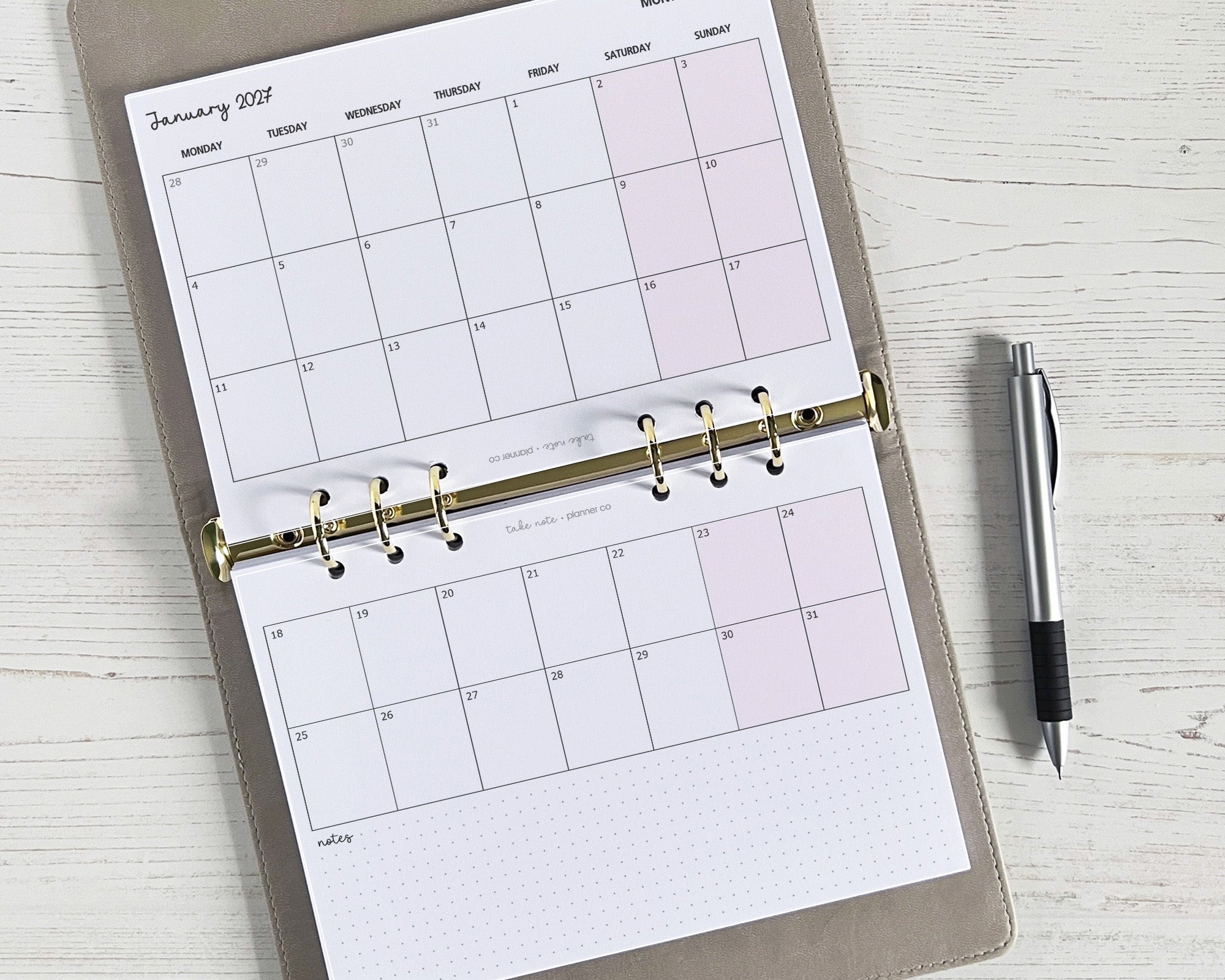 A5 monthly planner inserts with a landscape layout, displayed in an open planner, with a pen on the side.