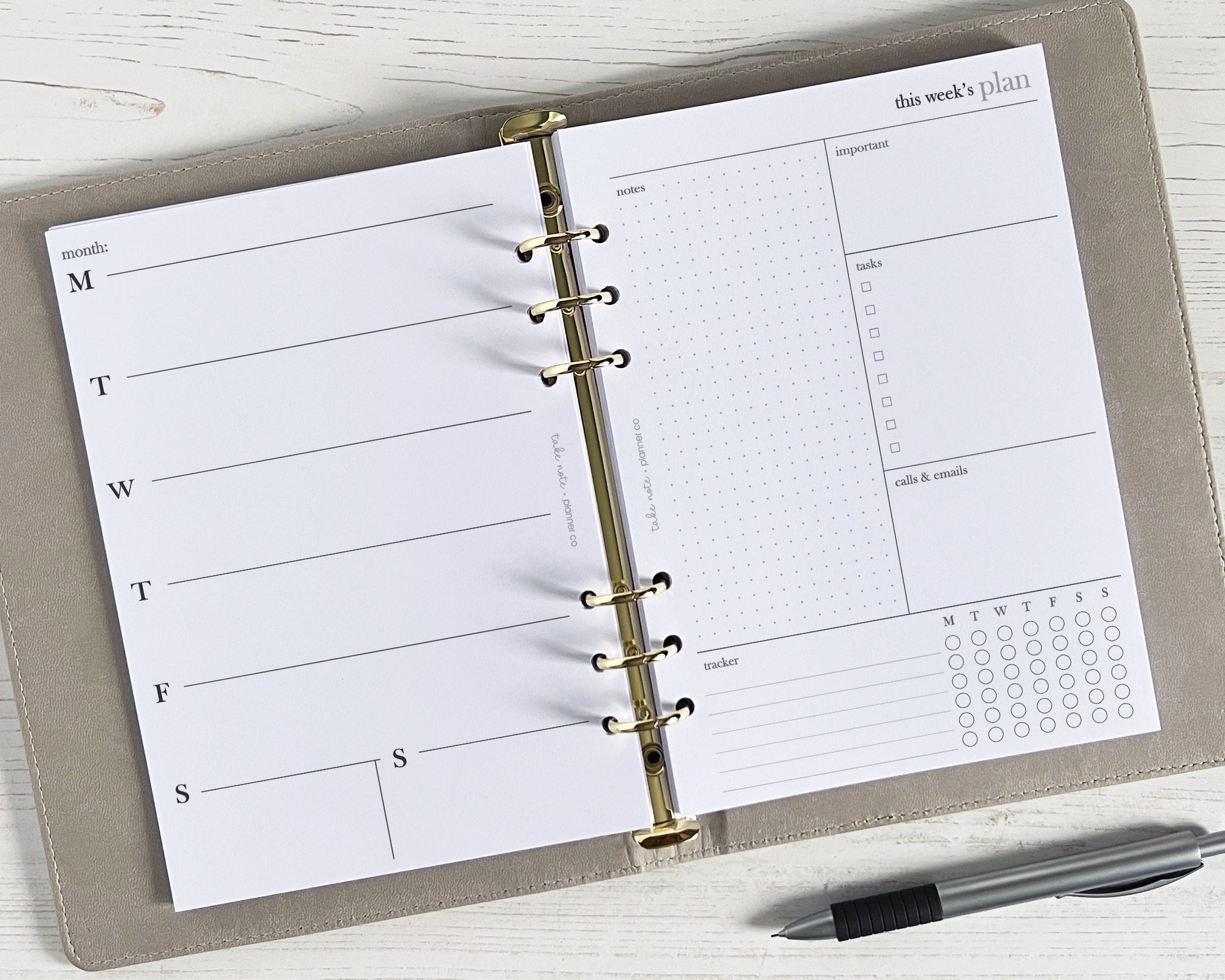 An open weekly planner insert with a simple minimalistic design, featuring space for notes and a to-do list, with a pen beside it.