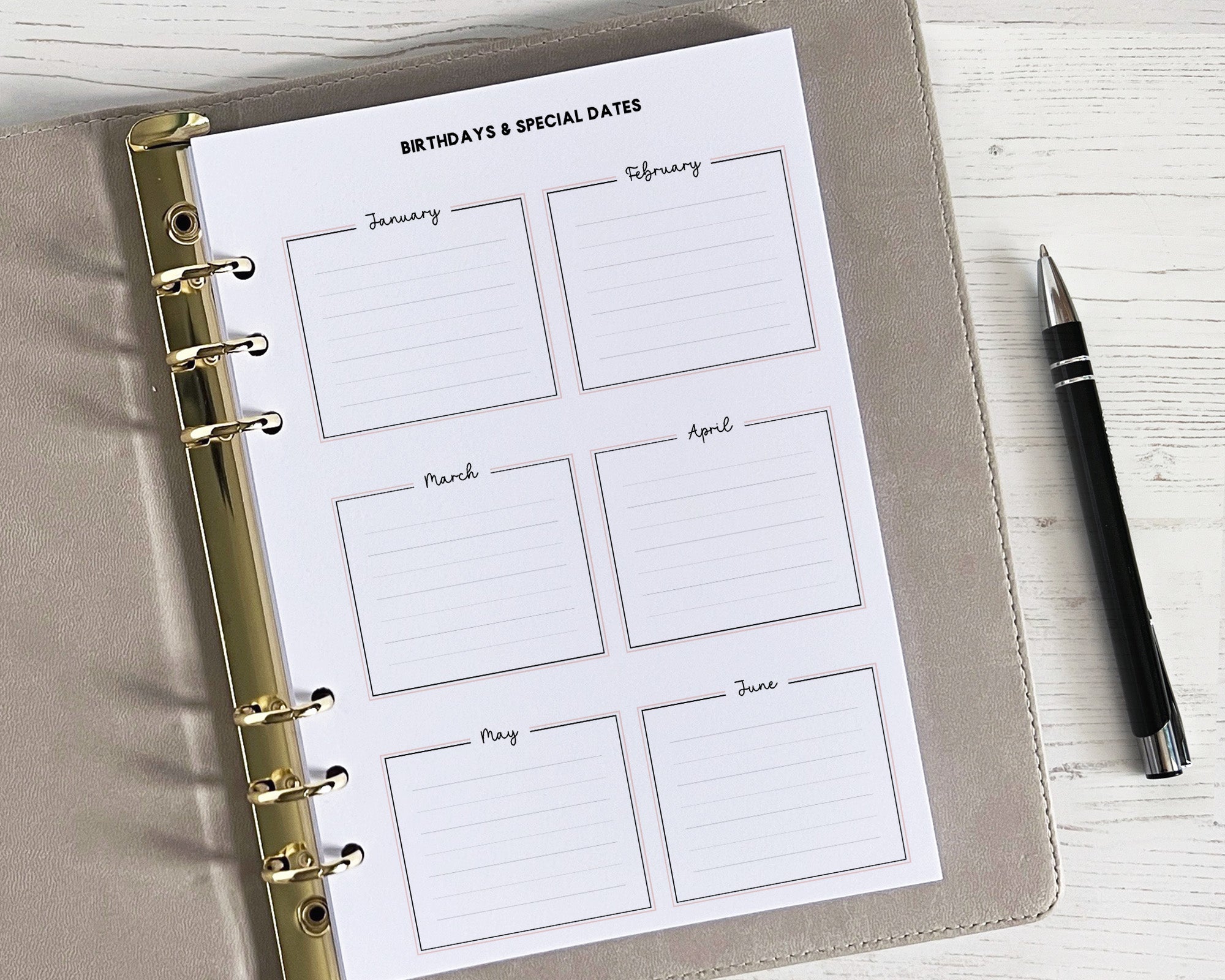 A5 size yearly overview insert with undated months, written in a classic style with space for birthdays and special dates, placed inside a planner with a pen beside it.