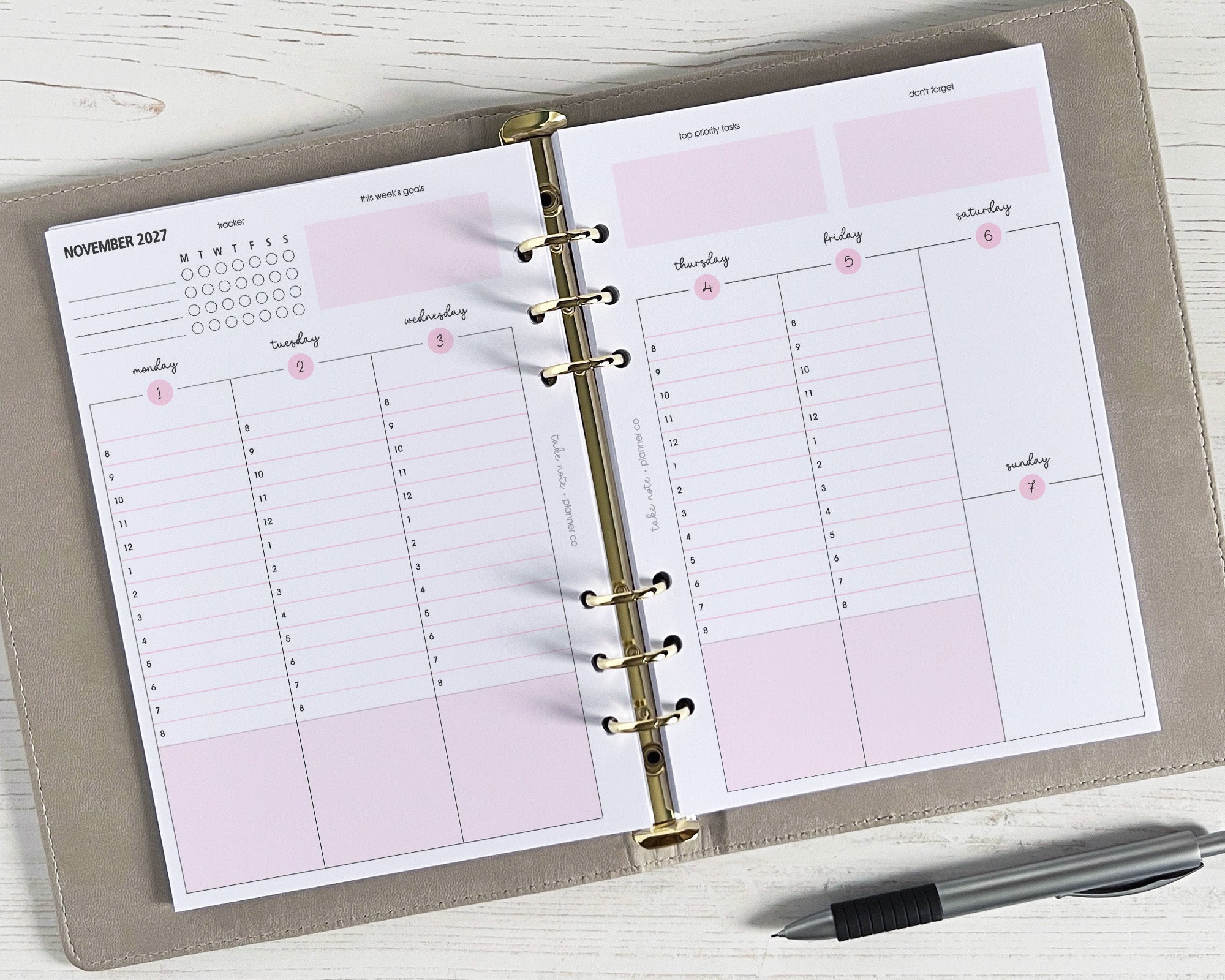 A5 weekly planner inserts displayed open with a pen beside it, showing a vertical two-page spread with space for notes and appointments, and a handy habit tracker.