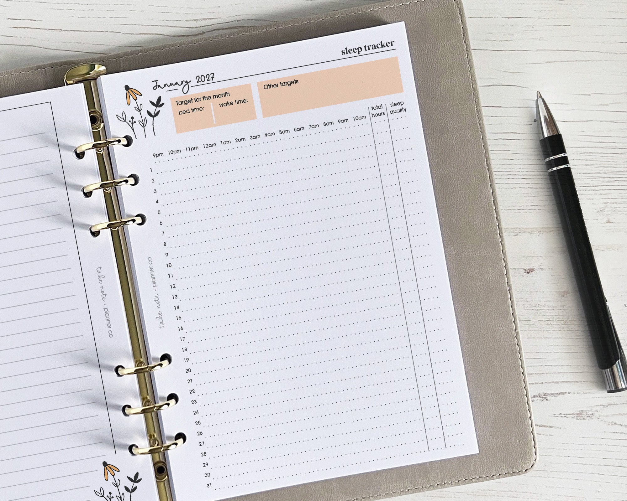 Planner with sleep tracker page on a white surface next to a pen
