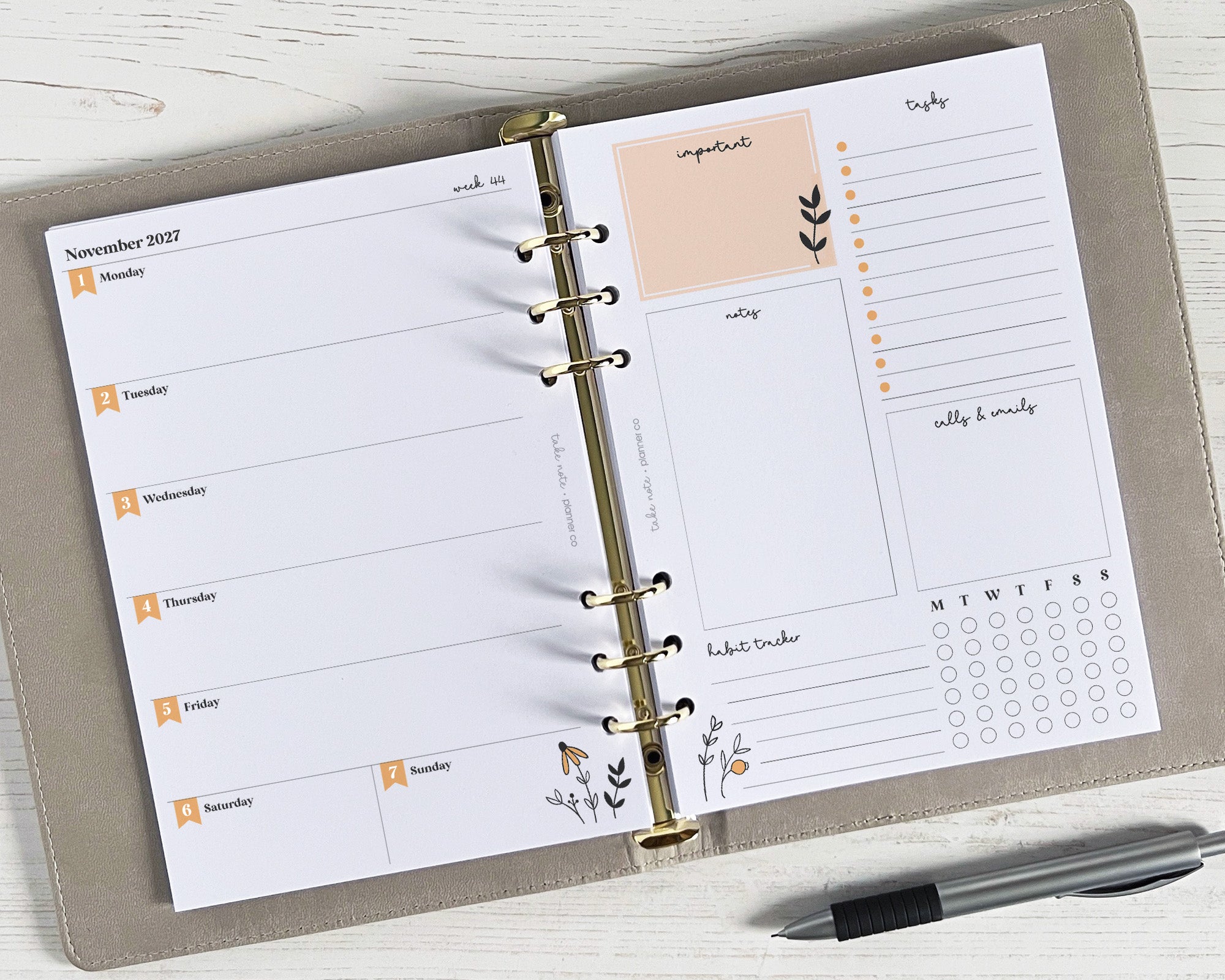 A weekly planner insert with a floral design, featuring spaces for notes, appointments, and a tasks list, lying flat on a surface with a pen next to it.