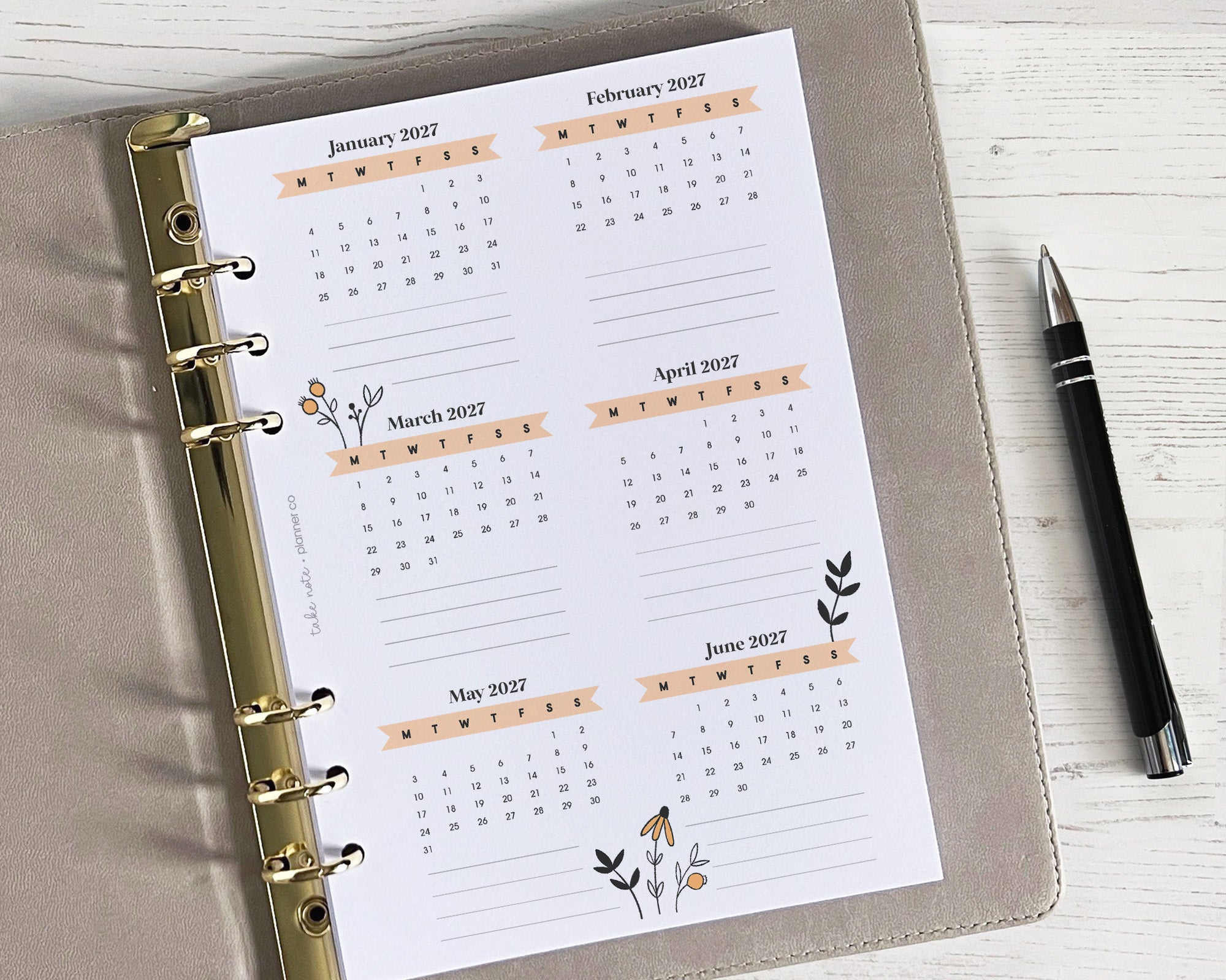 A yearly overview insert with a floral design, placed inside a binder, ready for use in a planner.