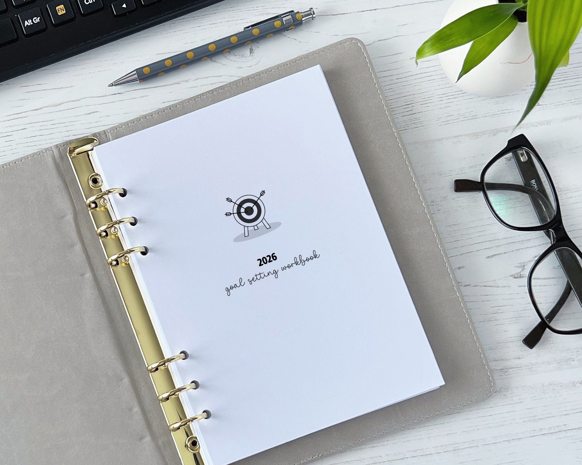 2026 goal setting workbook on a desk with glasses and a plant