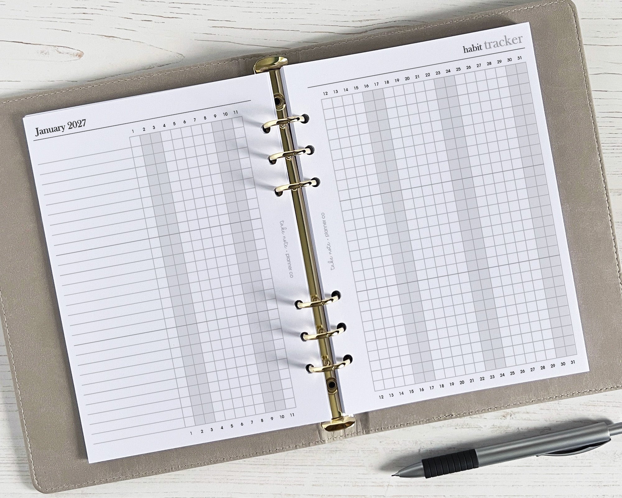 Open planner with habit tracker page on a white surface